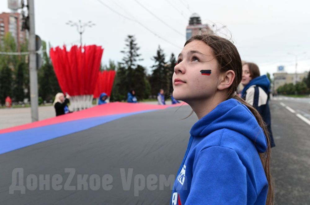 В знак памяти: молодежь развернула в центре Донецка 200-метровый флаг ДНР В знак памяти: молодежь развернула в центре Донецка 200-метровый флаг ДНР