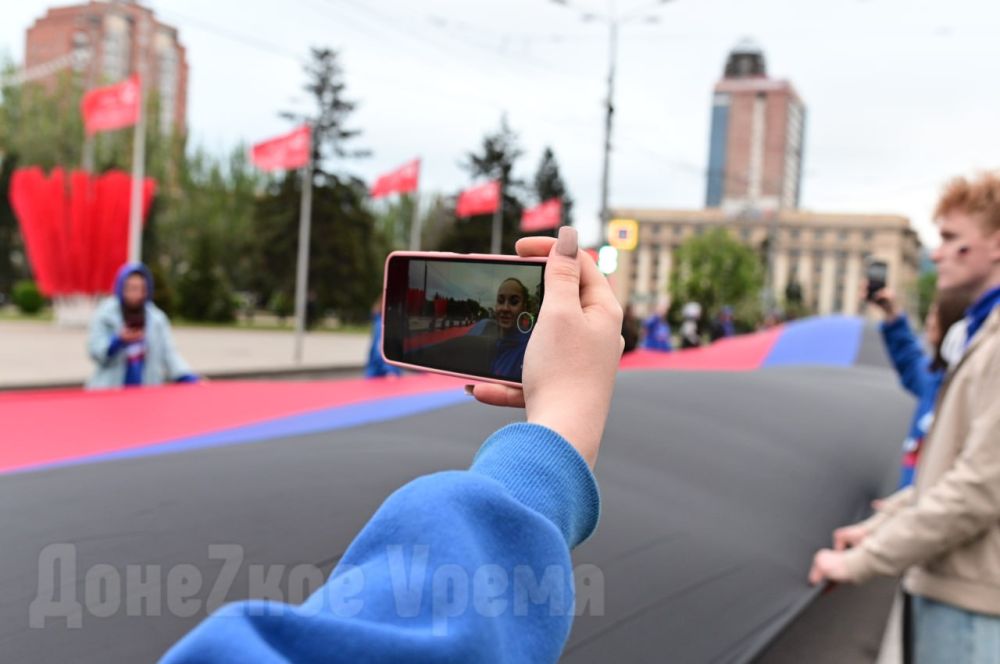 В знак памяти: молодежь развернула в центре Донецка 200-метровый флаг ДНР В знак памяти: молодежь развернула в центре Донецка 200-метровый флаг ДНР