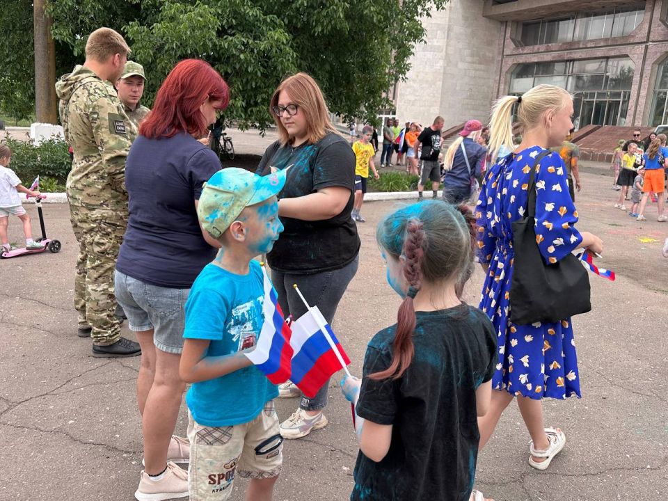 Раздача лент и флажков в цвет российского триколора Раздача лент и флажков в цвет российского триколора