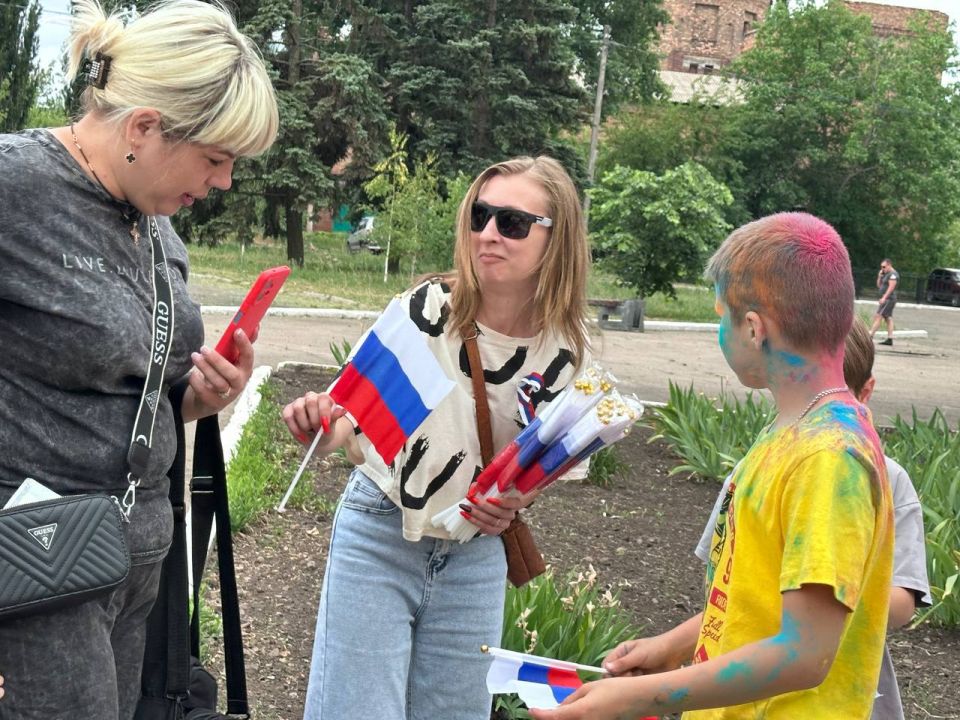 Раздача лент и флажков в цвет российского триколора Раздача лент и флажков в цвет российского триколора