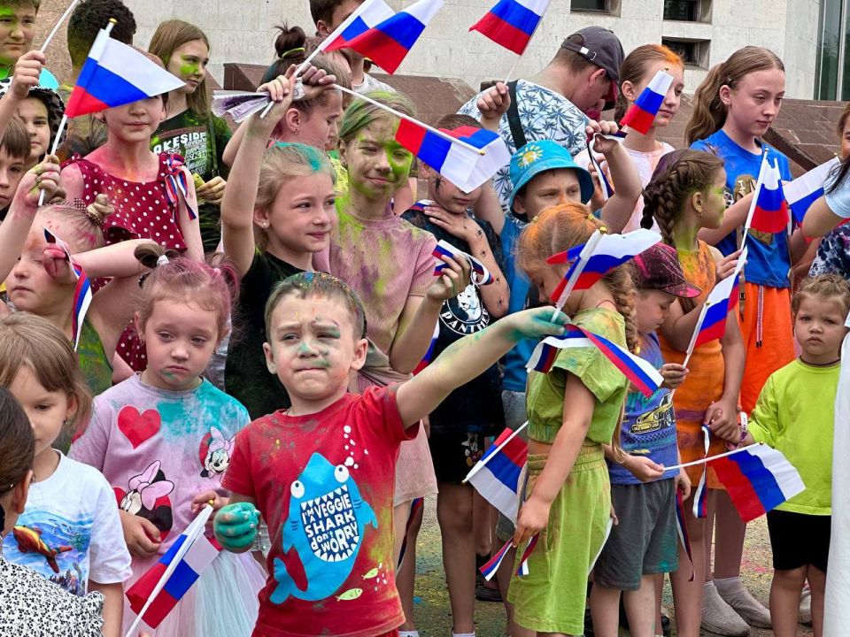 Раздача лент и флажков в цвет российского триколора Раздача лент и флажков в цвет российского триколора