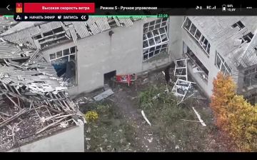 Бойцы ВС РФ демонстрируют флаг подразделения в застройке на юго-востоке Родинского