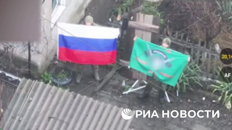 Минобороны показало российских бойцов, которые держат в руках российский триколор в освобожденном населенном пункте Ровное в ДНР