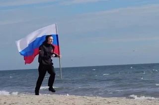 Дружинник из Мариуполя пробежал набережную с флагом в день рождения Путина